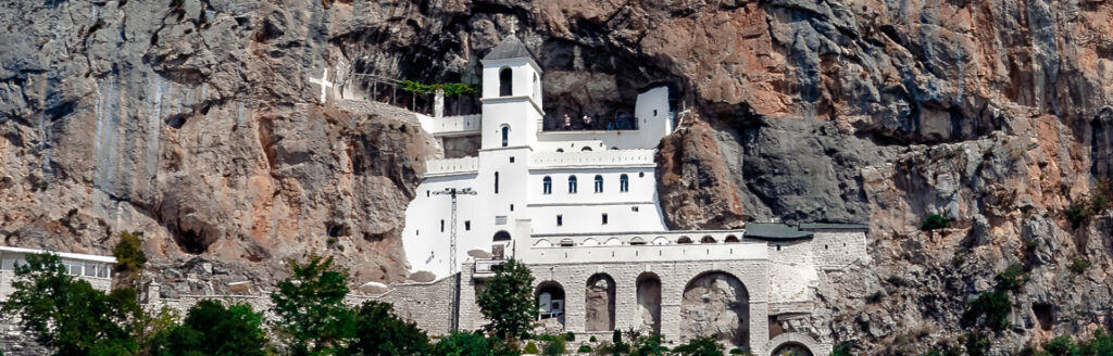 Urlaub Montenegro DIE KLÖSTER VON MONTENEGRO Was man nicht verpassen darf sind die vielen Klöster in Montenegro. Das meistbesuchte Kloster ist Ostrog. Eingemeißelt in einem Fels auf einer Höhe von 900 Metern, stellt das Kloster einen wichtigen geistlichen Mittelpunkt des Christentums und einen Wallfahrtsort dar. Die Besucher können hier Ruhe und eine geistliche Erneuerung erfahren und den Blick auf die umliegenden Berge und Bjelopavlićka ravnica genießen.